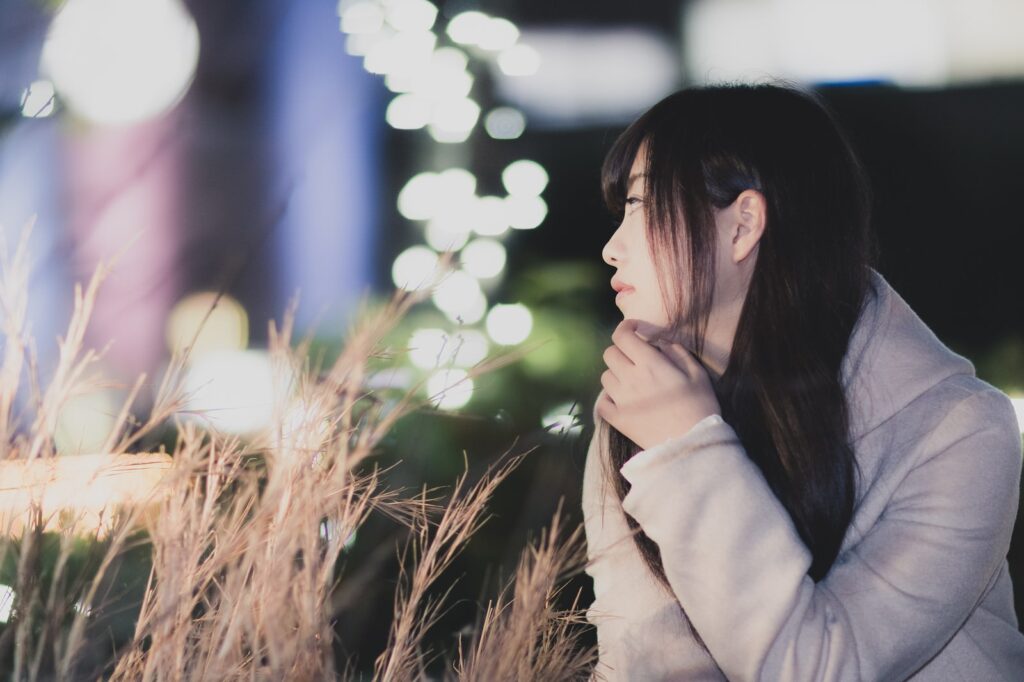 夜の街で進路について考える大学生(イメージ)